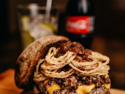 burger-sandwich-and-cola-on-wooden-surface-2983104-r3bb88mmu0y25sy67hnd5jlyd1g3mu4yem98fx4ud4